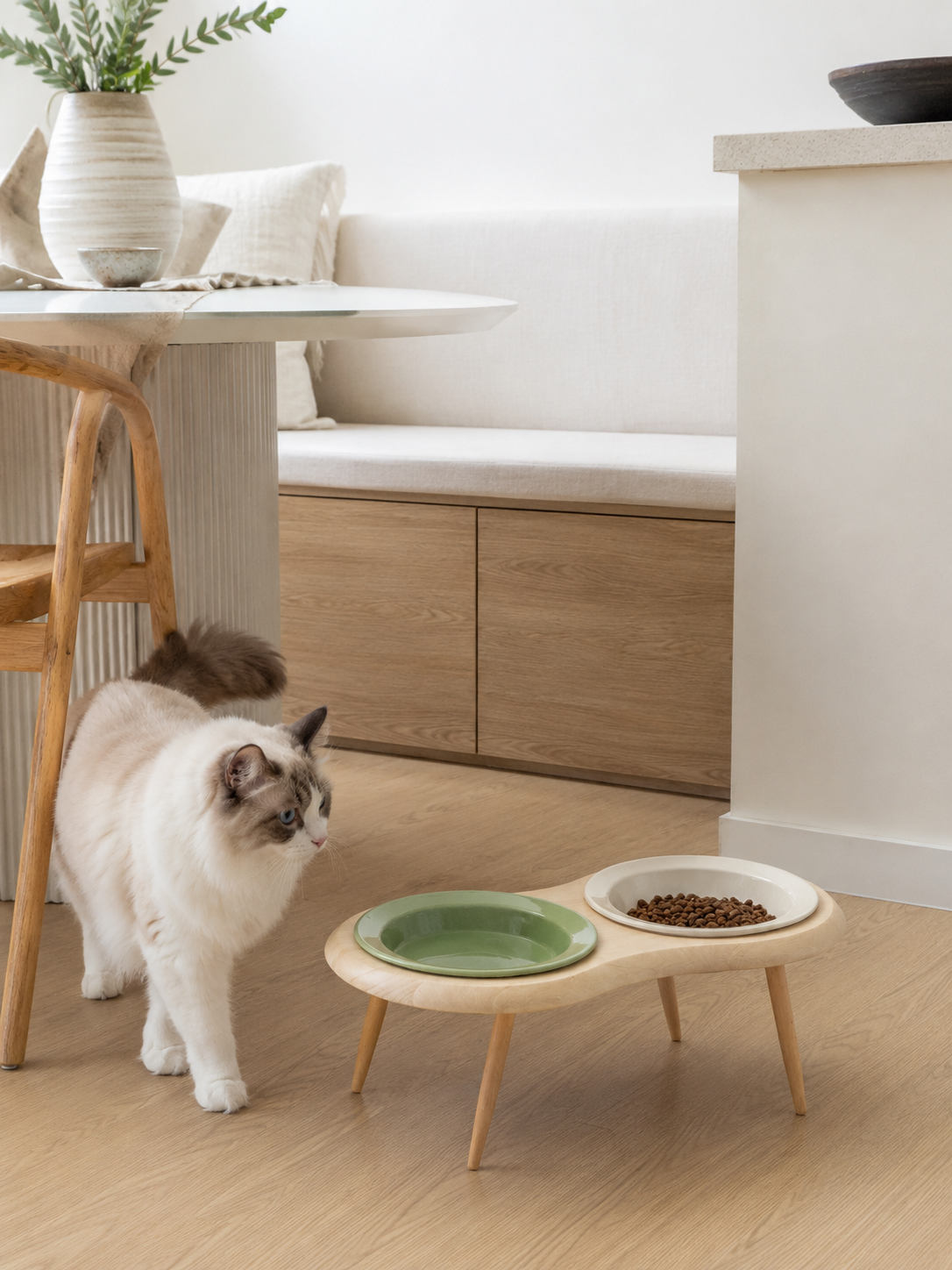 Elevated cat feeding station with two ceramic bowls on wooden legs in modern Australian kitchen